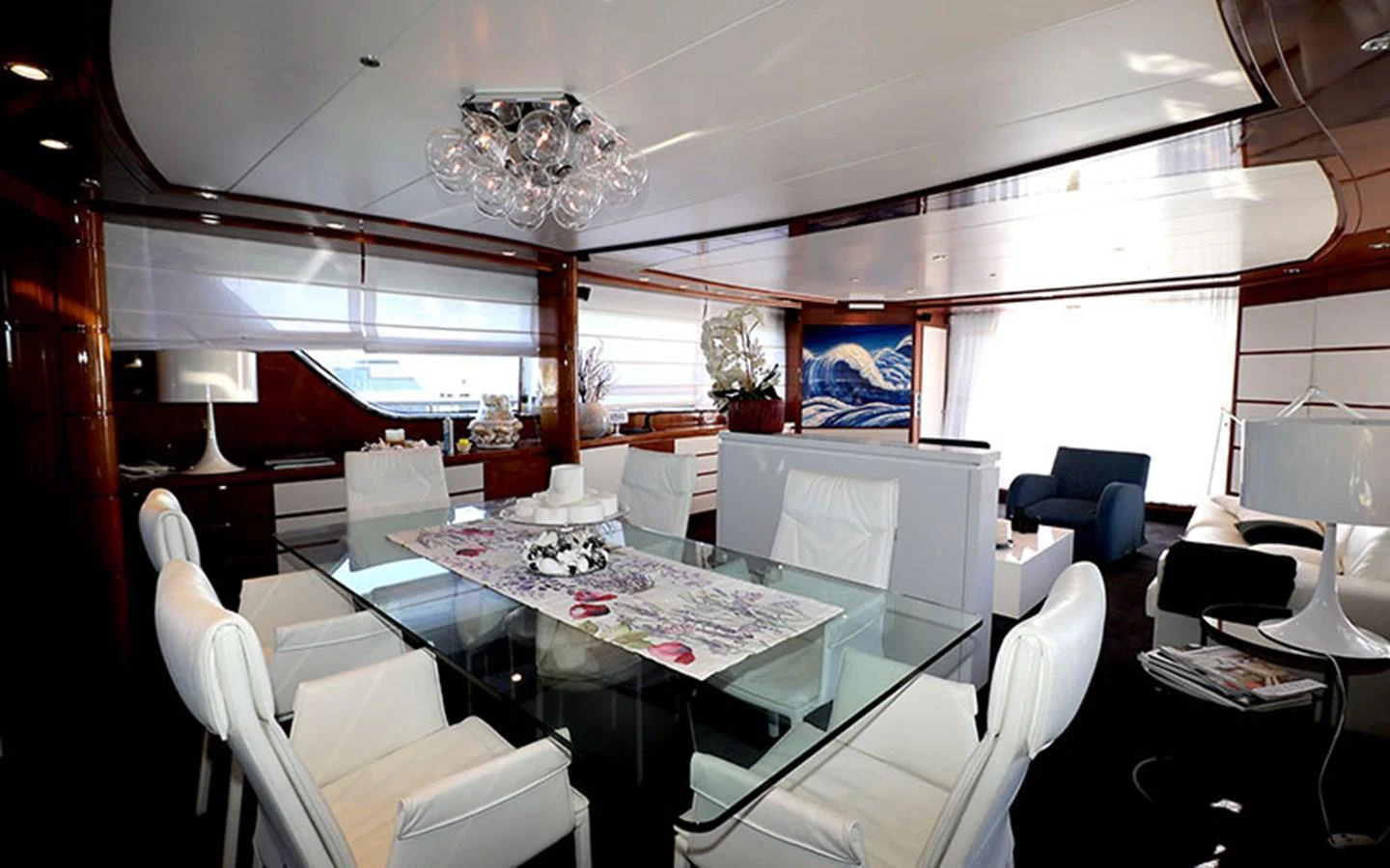 The yacht's dining area features a modern glass table and plush white seating, exuding elegance and comfort. aboard MEP TOGETHER Yacht for Sale