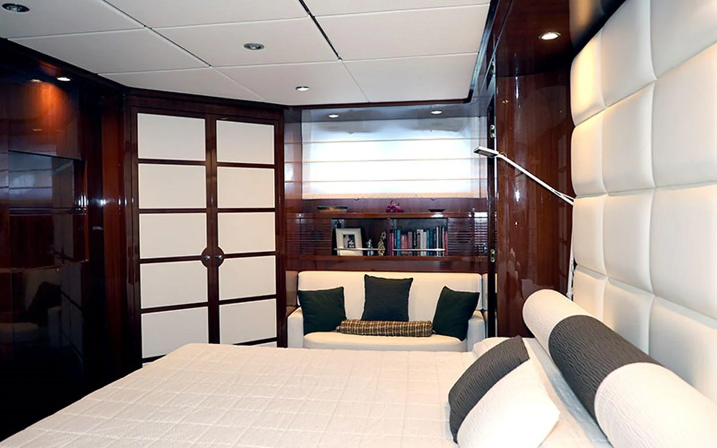 The stateroom features a plush bed, a cozy seating area, and elegant wood paneling. aboard MEP TOGETHER Yacht for Sale