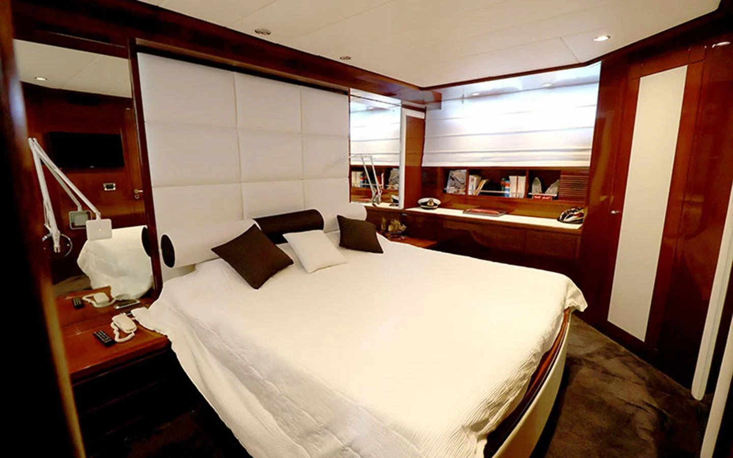 A luxurious stateroom featuring a large bed with plush pillows and elegant wood finishes. aboard MEP TOGETHER Yacht for Sale