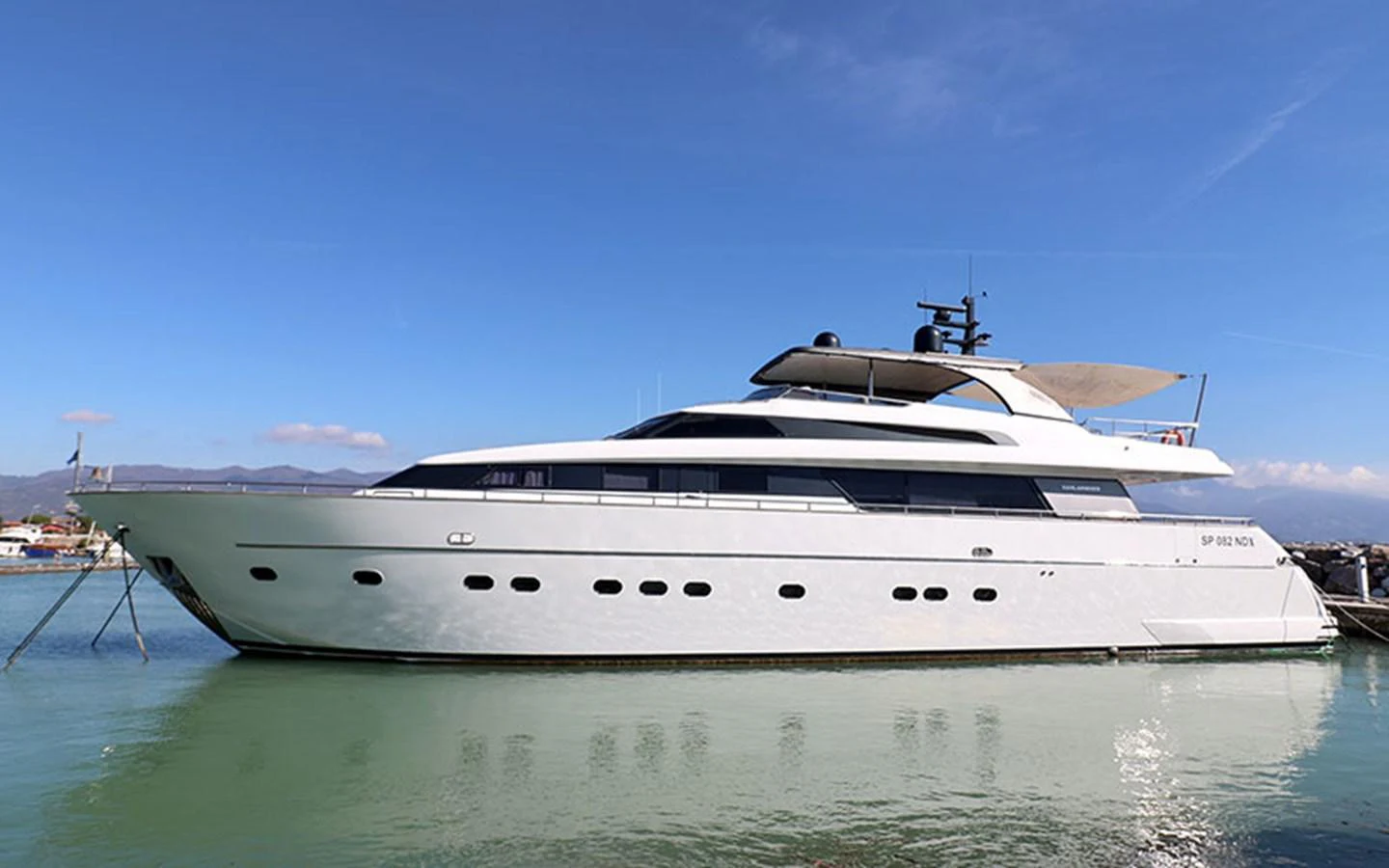 A sleek and modern yacht is docked, showcasing its elegant profile against a clear blue sky. aboard MEP TOGETHER Yacht for Sale