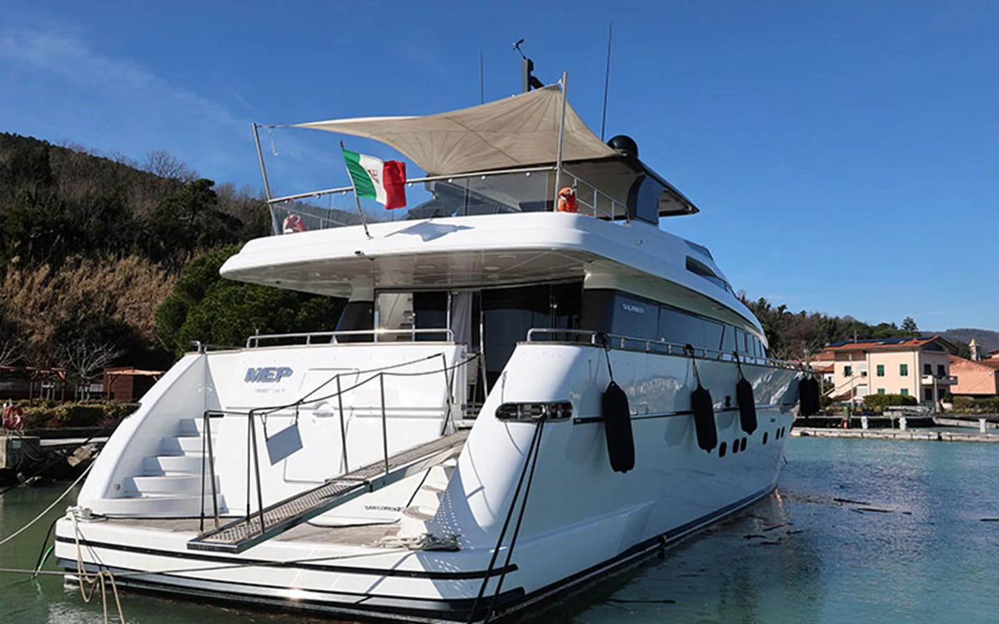 A luxurious yacht is docked in a serene marina, showcasing its elegant aft deck and sleek design. aboard MEP TOGETHER Yacht for Sale