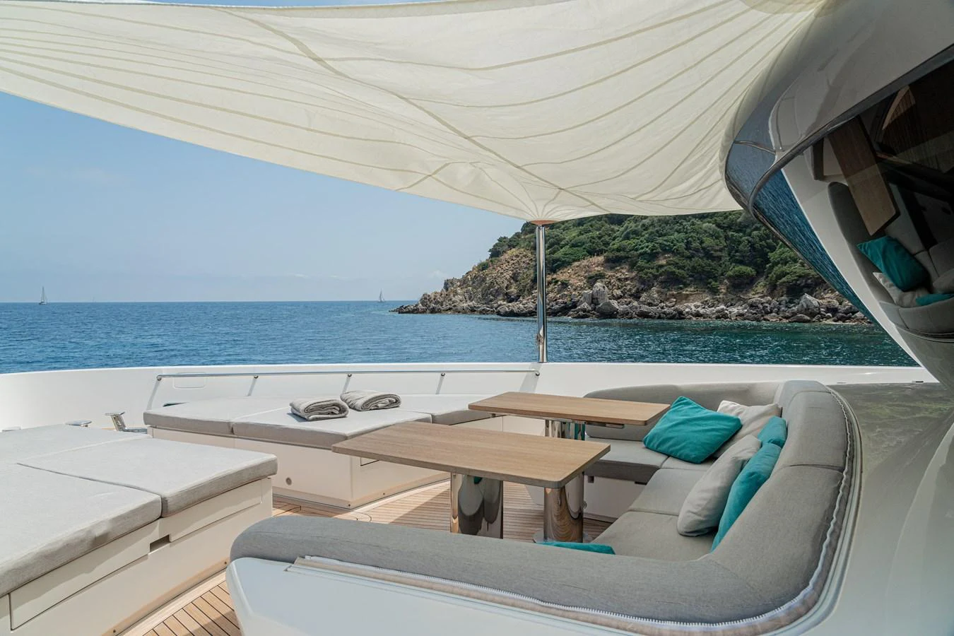 The aft deck features a comfortable seating area with a dining table, shaded by a sail canopy, perfect for relaxation and dining while enjoying the sea view. aboard SANLORENZO SX 88 M&M Yacht for Sale