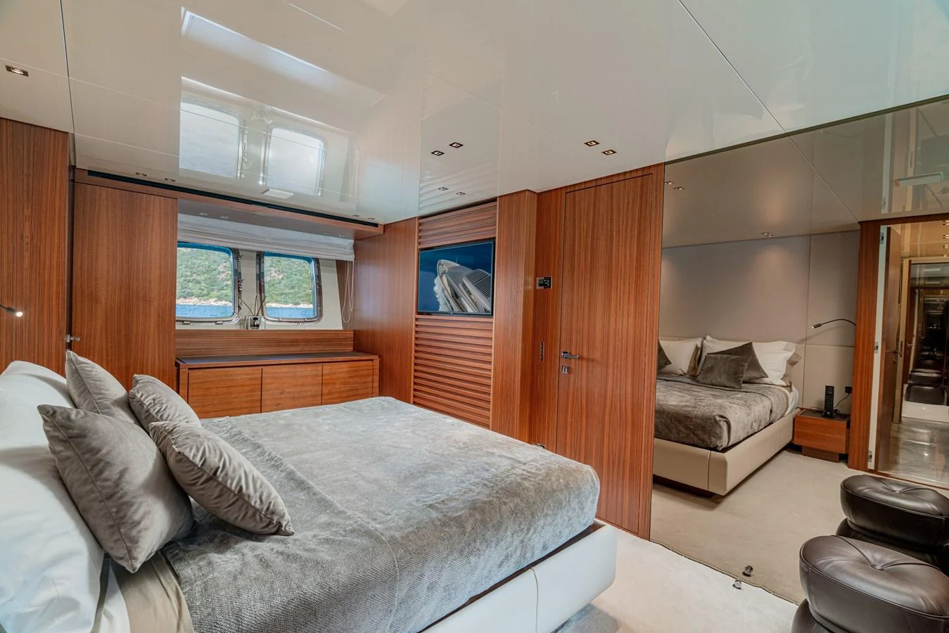 The master stateroom features luxurious bedding, warm wood finishes, and ample natural light. aboard SANLORENZO SX 88 M&M Yacht for Sale