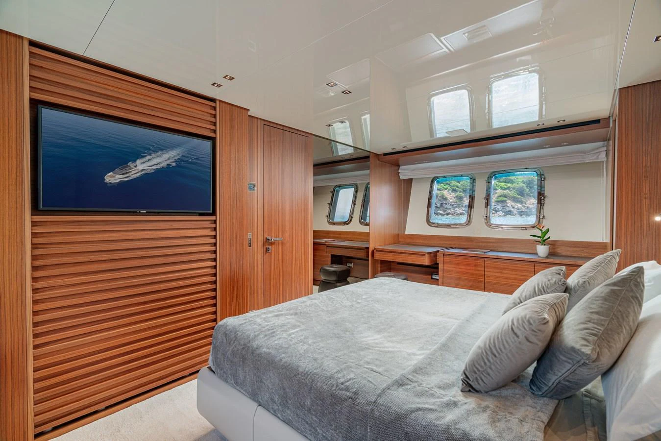 A luxurious stateroom featuring a large bed, wooden accents, and ample natural light from the windows. aboard SANLORENZO SX 88 M&M Yacht for Sale