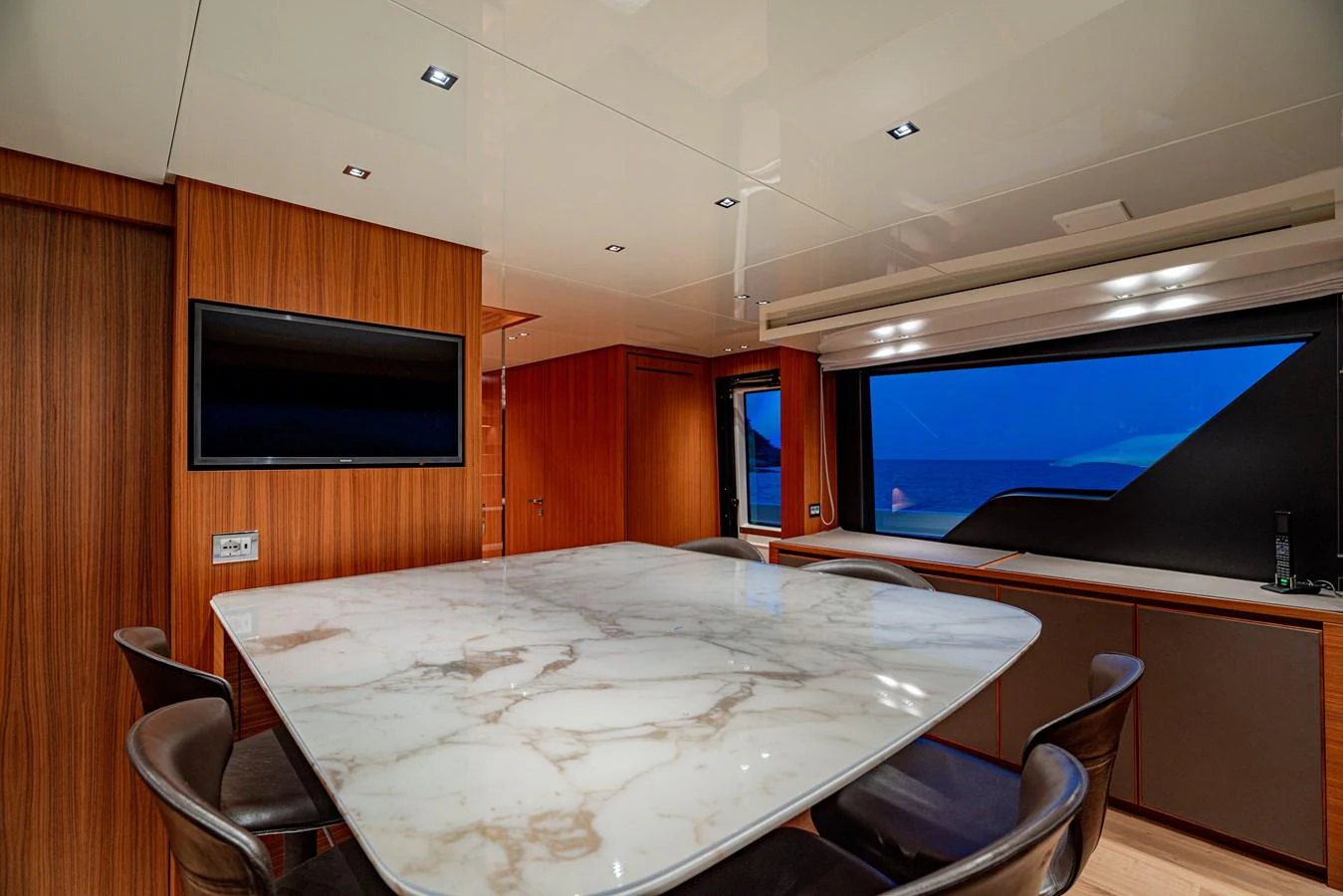 The yacht's dining area features a luxurious marble table surrounded by comfortable seating and large windows offering stunning ocean views. aboard SANLORENZO SX 88 M&M Yacht for Sale