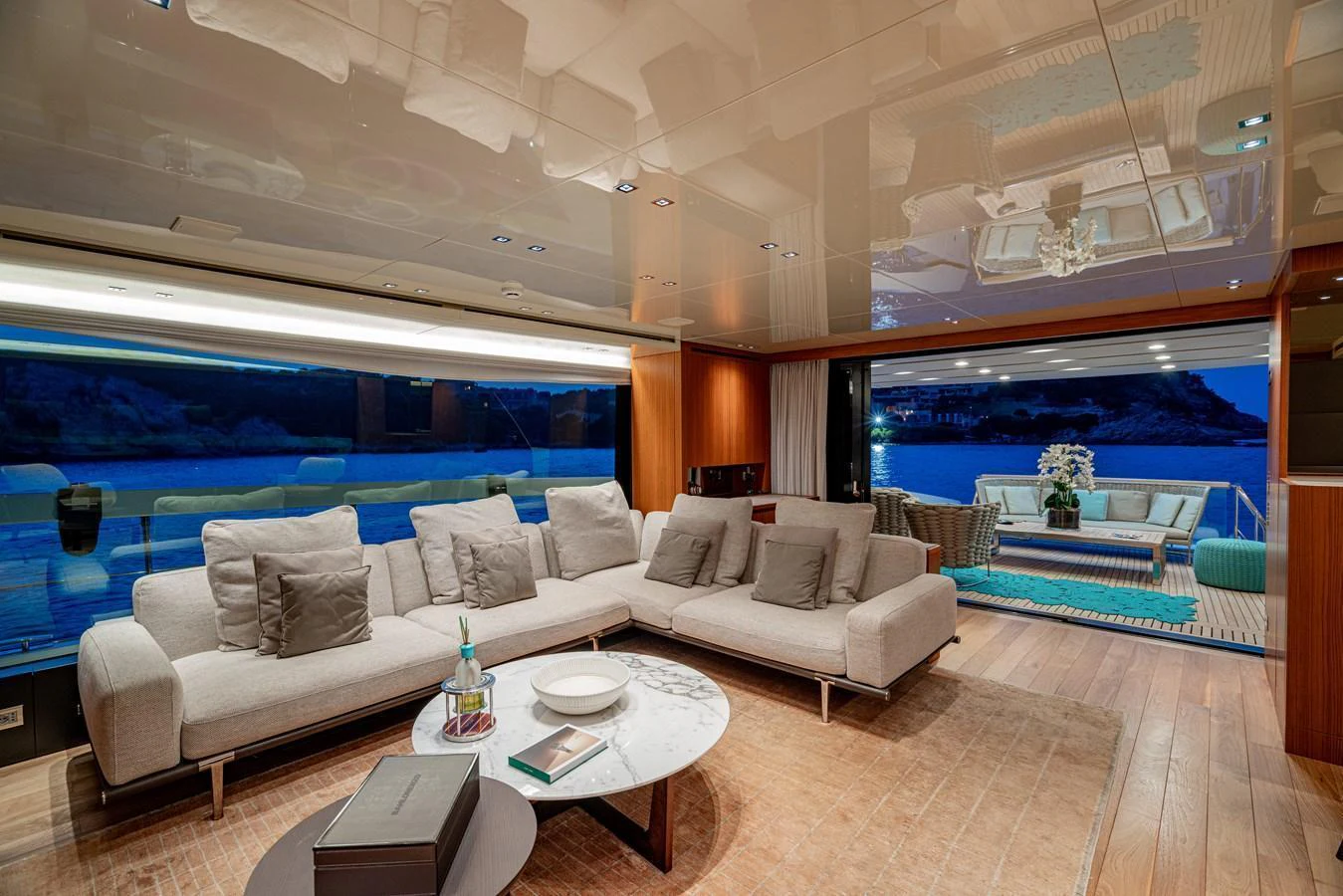 The yacht's salon features a spacious and elegant seating area with a view of the outdoor deck. aboard SANLORENZO SX 88 M&M Yacht for Sale