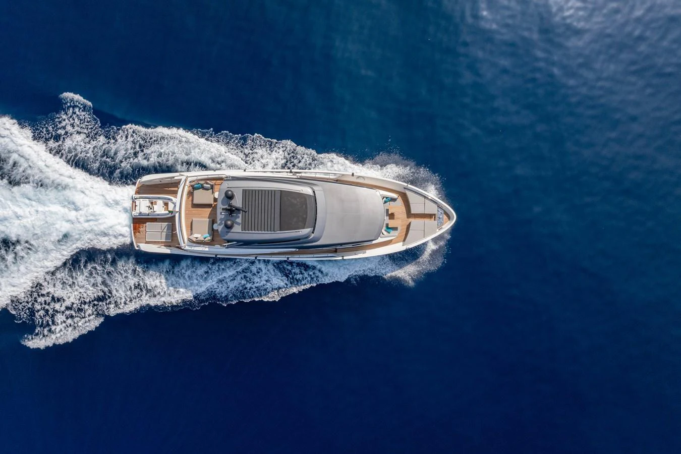 A sleek yacht cruises through the deep blue sea, leaving a trail of white wake behind. aboard SANLORENZO SX 88 M&M Yacht for Sale