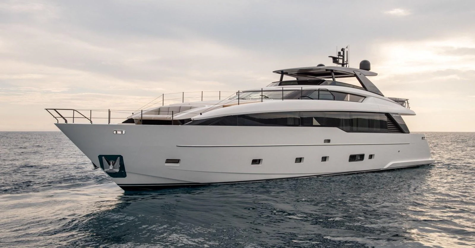A sleek and modern yacht cruising on calm waters under a cloudy sky. aboard TELL NO ONE Yacht for Sale