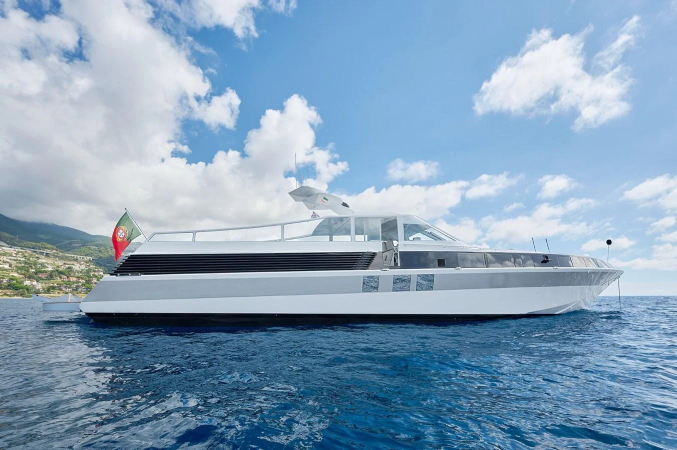 A sleek, modern yacht glides gracefully on calm blue waters under a bright sky. aboard ZARKAVA Yacht for Sale