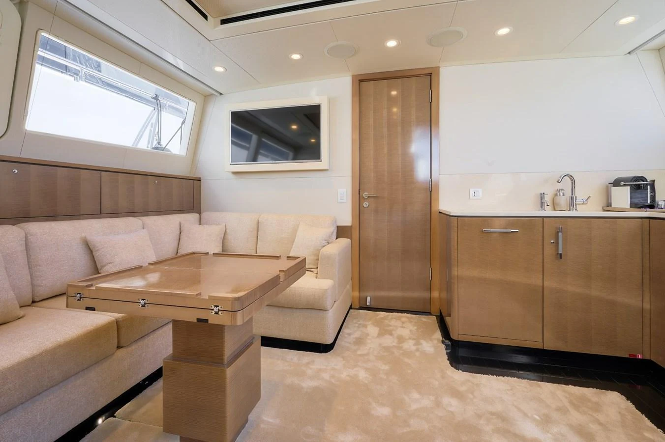The salon features a cozy seating area with a modern entertainment system and a compact kitchenette. aboard ZARKAVA Yacht for Sale