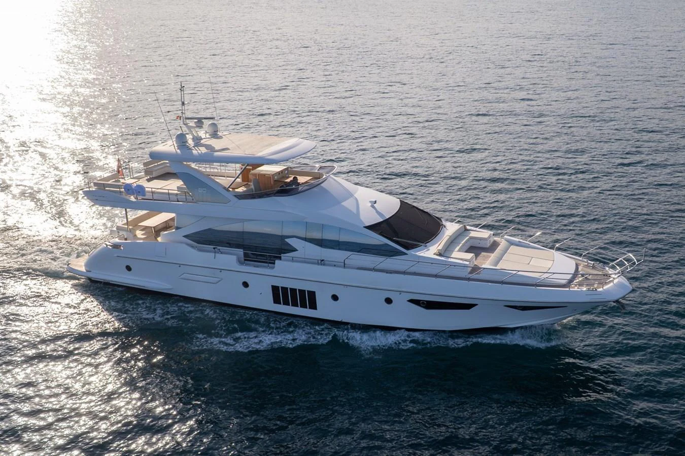 A sleek and modern yacht cruising on calm waters under the sun. aboard TRINIDAD Yacht for Sale