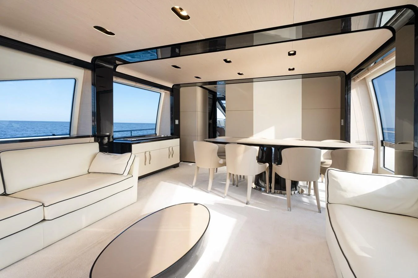 The salon features elegant seating and a dining area with panoramic ocean views. aboard TRINIDAD Yacht for Sale