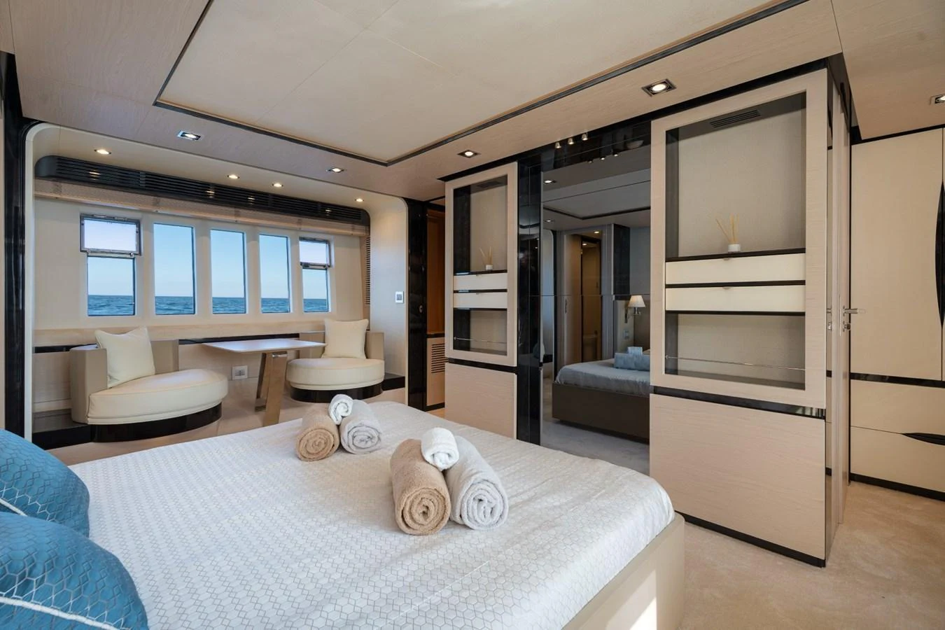 The master stateroom features a luxurious bed, elegant seating area, and ample natural light from large windows. aboard TRINIDAD Yacht for Sale