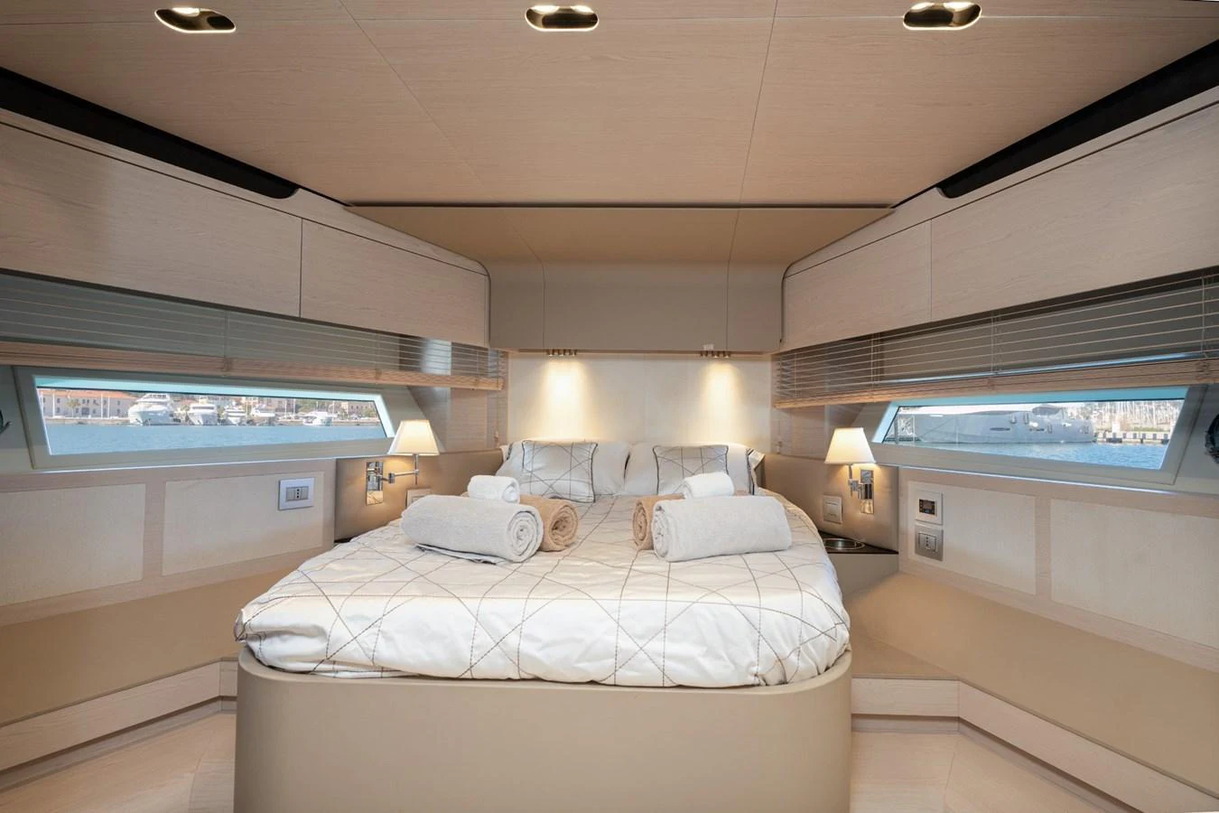 The stateroom features a luxurious bed with elegant linens and ample natural light from large windows. aboard TRINIDAD Yacht for Sale
