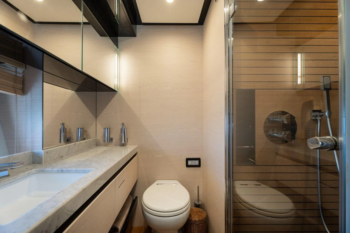 A modern yacht bathroom featuring a sleek vanity and a glass-enclosed shower. aboard TRINIDAD Yacht for Sale