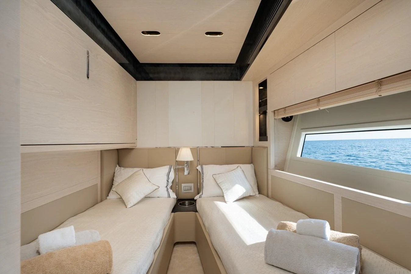 The guest stateroom features twin beds with a serene view of the sea through a large window. aboard TRINIDAD Yacht for Sale