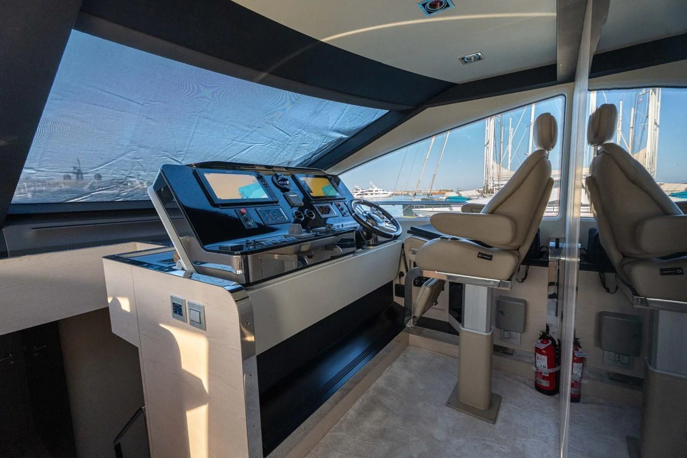 The helm station features modern navigation equipment and comfortable seating with a panoramic view. aboard TRINIDAD Yacht for Sale