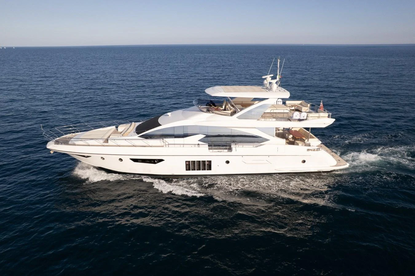 This sleek yacht glides effortlessly over the open sea, showcasing its modern design and spacious decks. aboard TRINIDAD Yacht for Sale