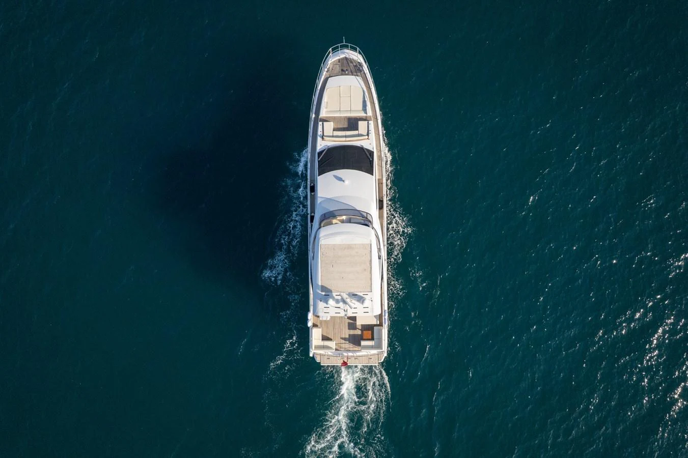 An aerial view of a luxurious yacht cruising through clear blue waters. aboard TRINIDAD Yacht for Sale