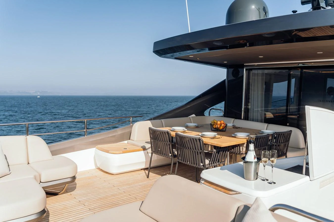 The aft deck features a stylish outdoor dining area with comfortable seating and a stunning ocean view. aboard CHASE Yacht for Sale