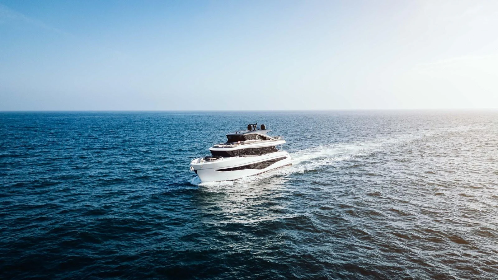 A sleek yacht cruises gracefully on the open sea under a clear blue sky. aboard CHASE Yacht for Sale