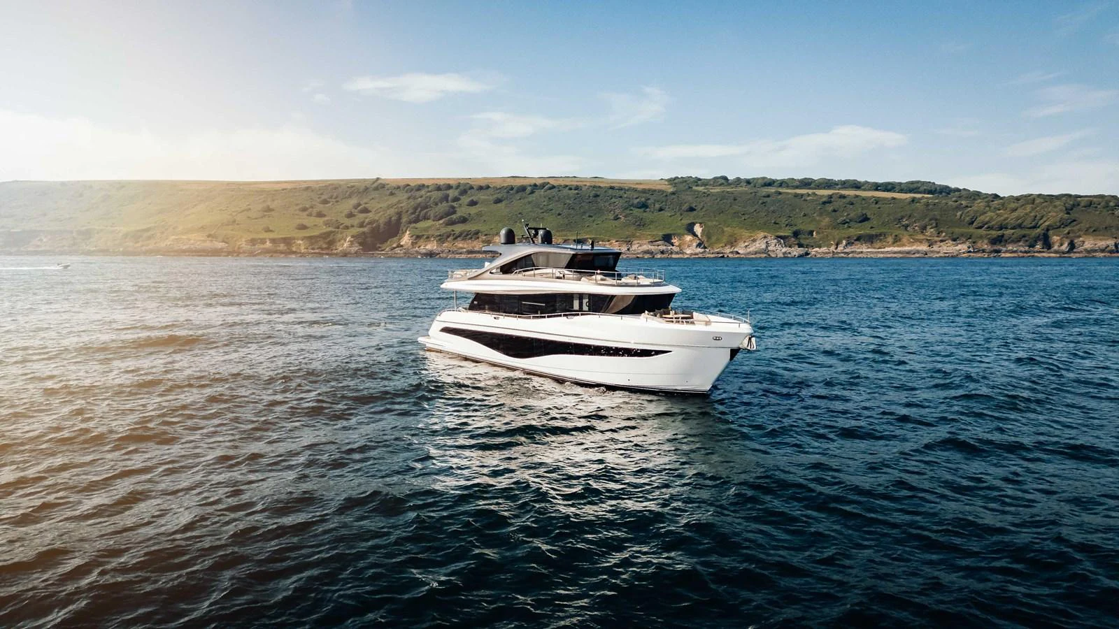 A sleek and modern yacht cruises gracefully on the open water against a scenic coastal backdrop. aboard CHASE Yacht for Sale