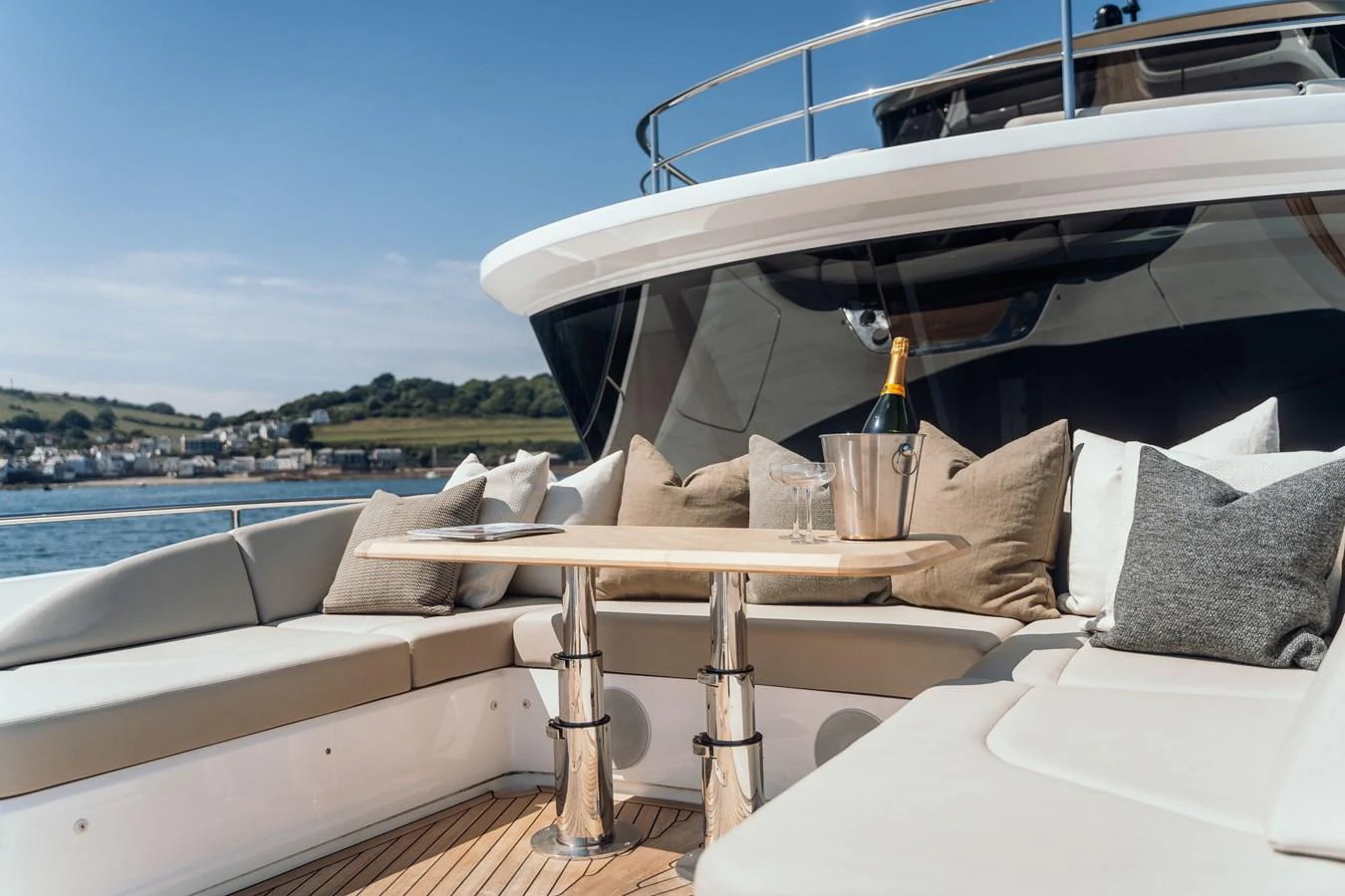 The aft deck features a luxurious seating area with a table and champagne, perfect for relaxation and socializing. aboard CHASE Yacht for Sale
