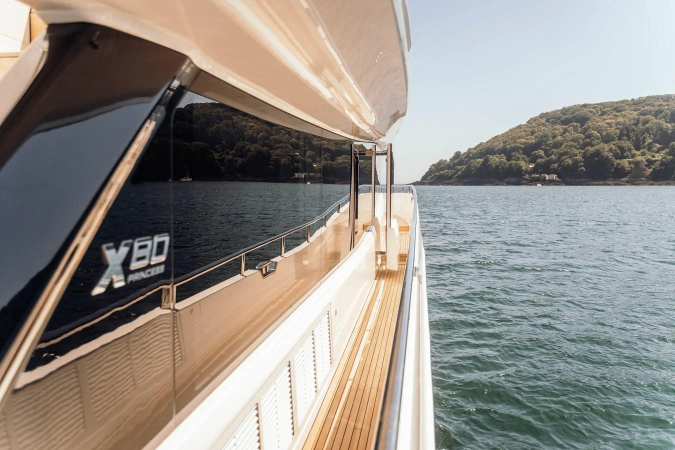 The yacht's sleek exterior showcases a polished walkway with stunning views of the surrounding water and landscape. aboard CHASE Yacht for Sale