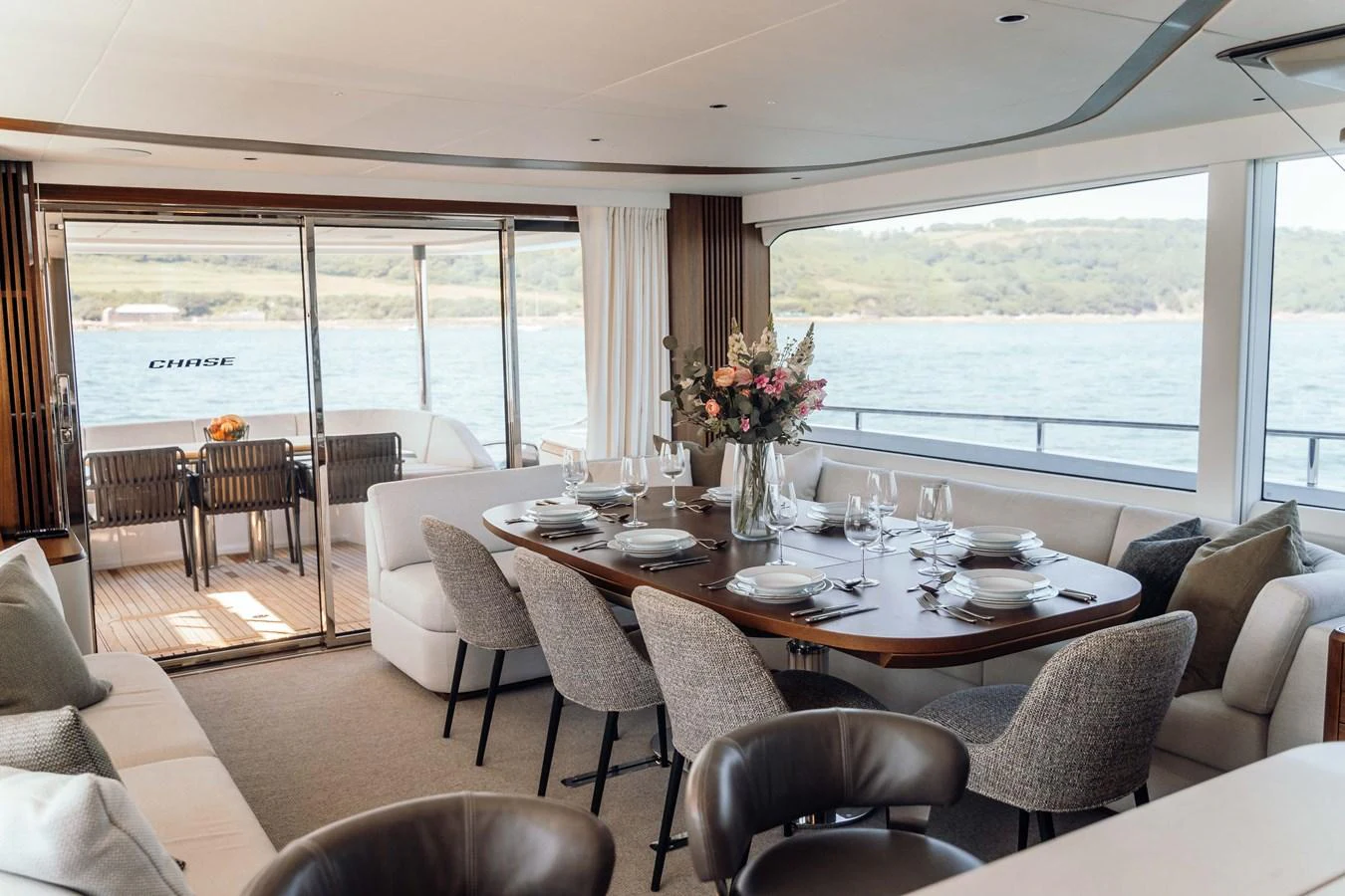 The yacht's dining area offers a luxurious setting with panoramic views and elegant table settings. aboard CHASE Yacht for Sale