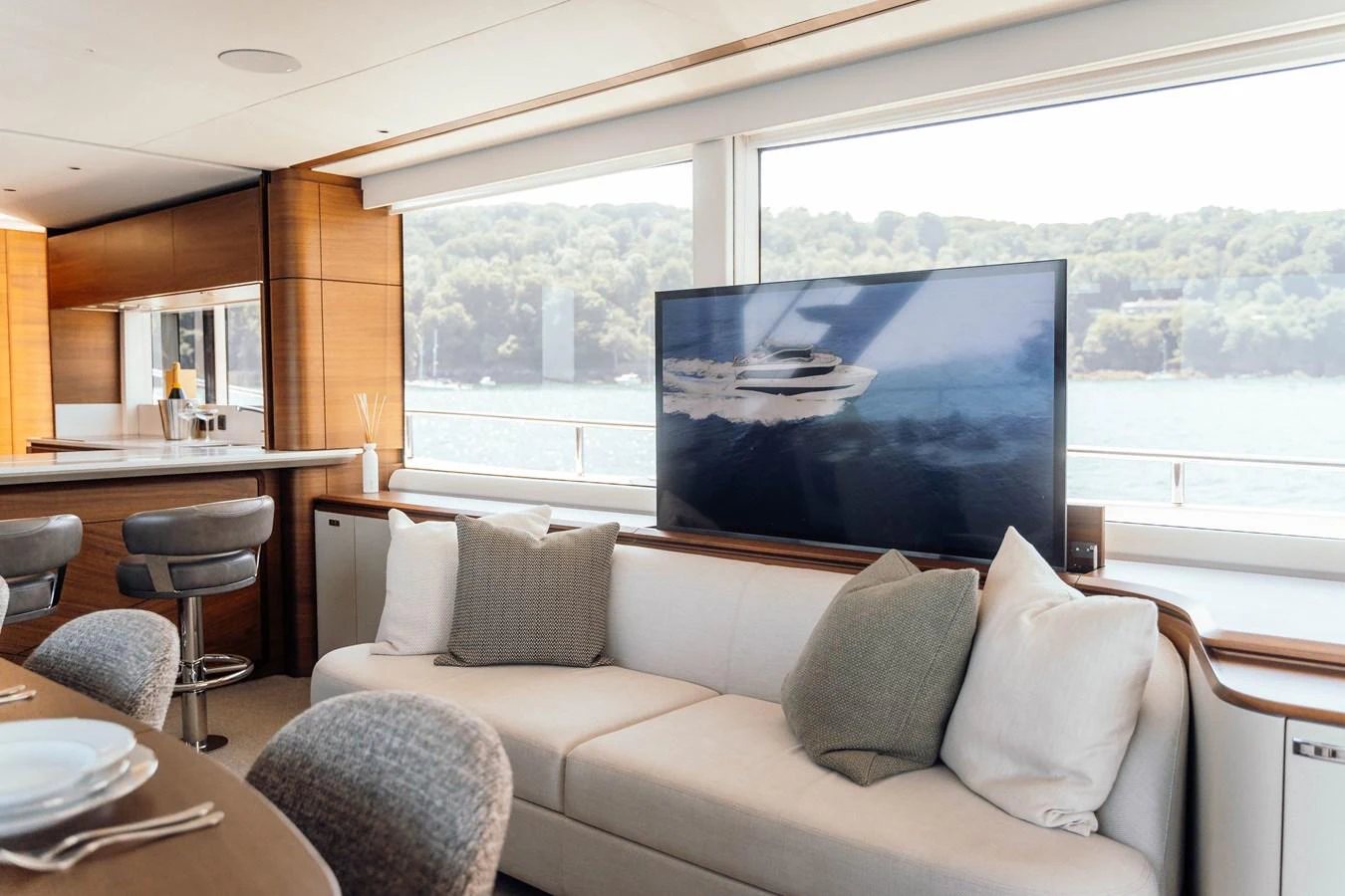 The salon features a comfortable seating area with a large window offering scenic views. aboard CHASE Yacht for Sale