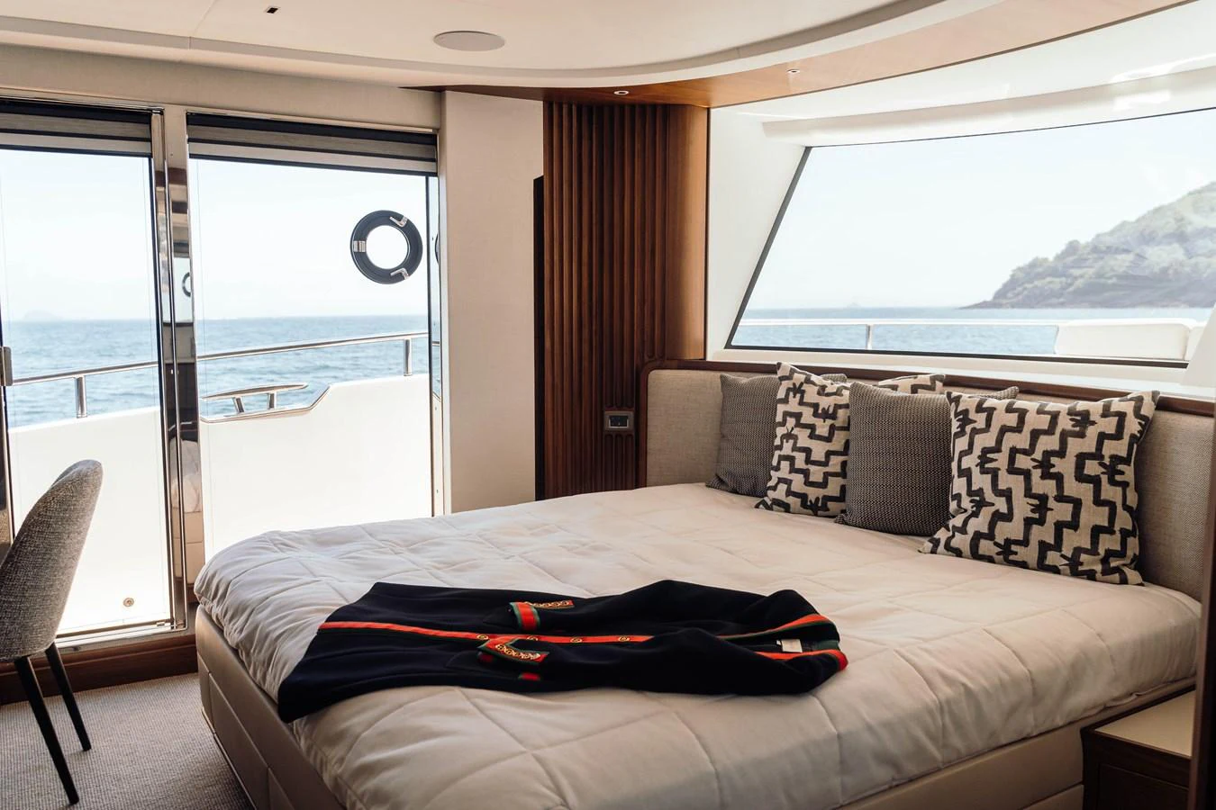 A luxurious stateroom with a large window offering a stunning sea view. aboard CHASE Yacht for Sale