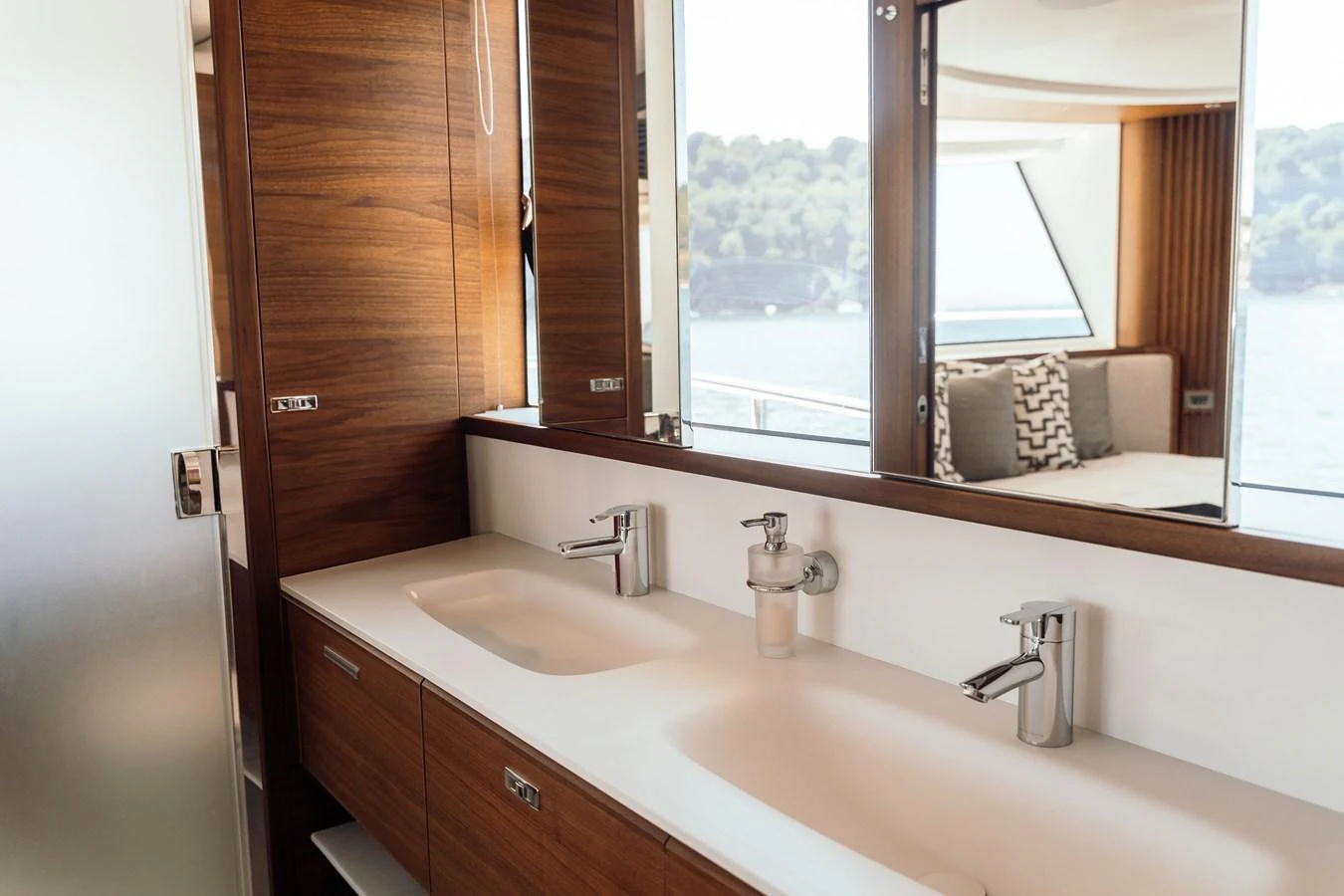 The yacht's bathroom features a sleek double sink with modern fixtures and a view of the sea. aboard CHASE Yacht for Sale