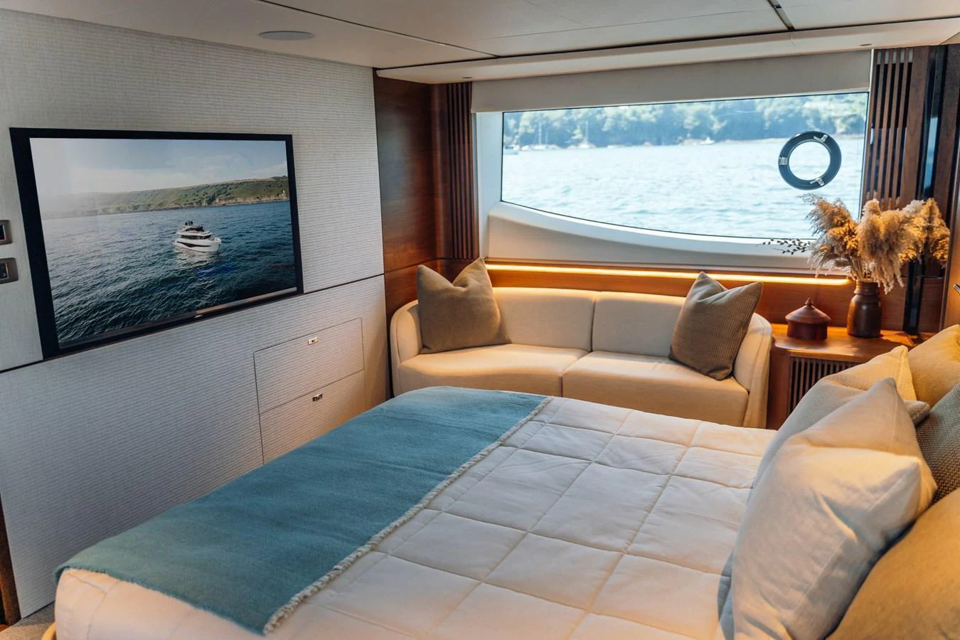 A cozy stateroom with a large window offering a scenic view of the water. aboard CHASE Yacht for Sale