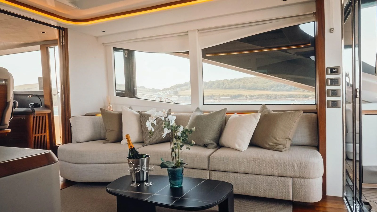 The salon features a comfortable seating area with large windows offering scenic views. aboard CHASE Yacht for Sale