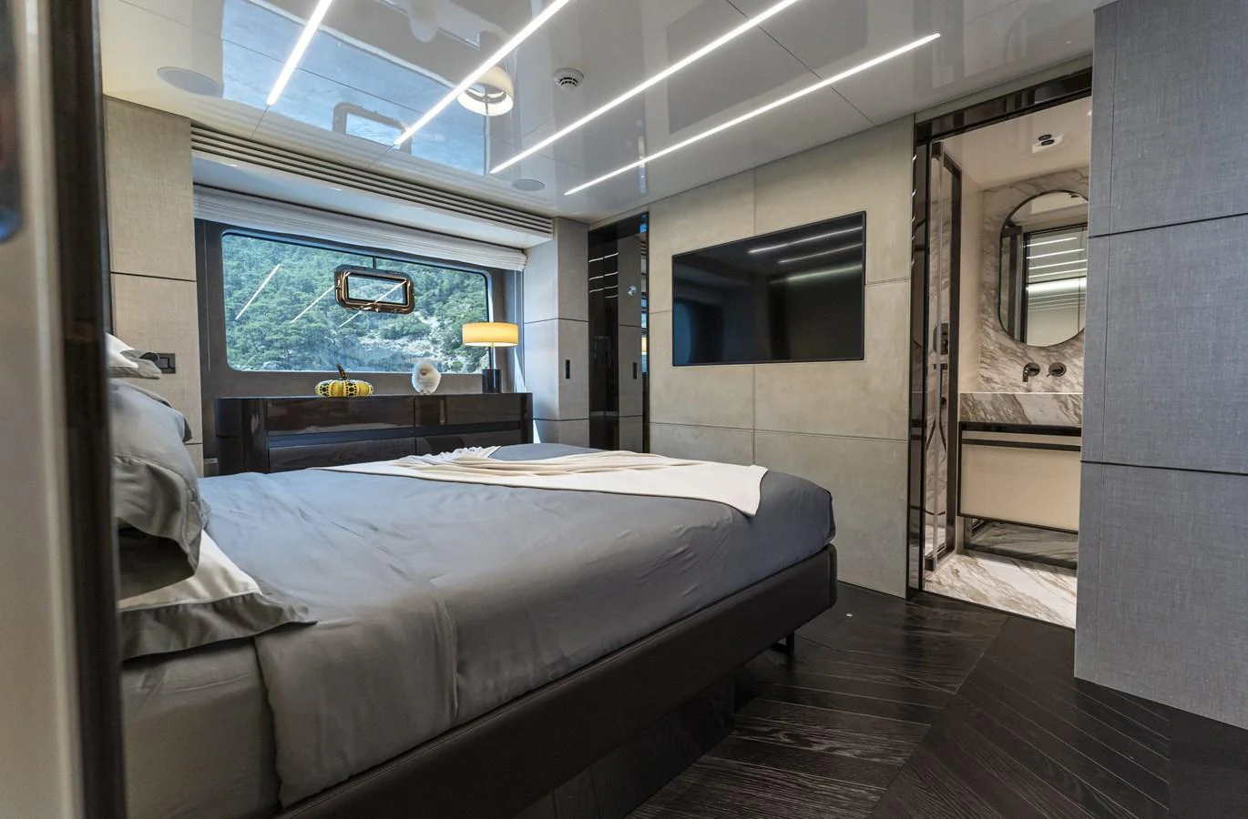A luxurious stateroom featuring a plush bed, modern decor, and an ensuite bathroom. aboard ORCA I Yacht for Sale
