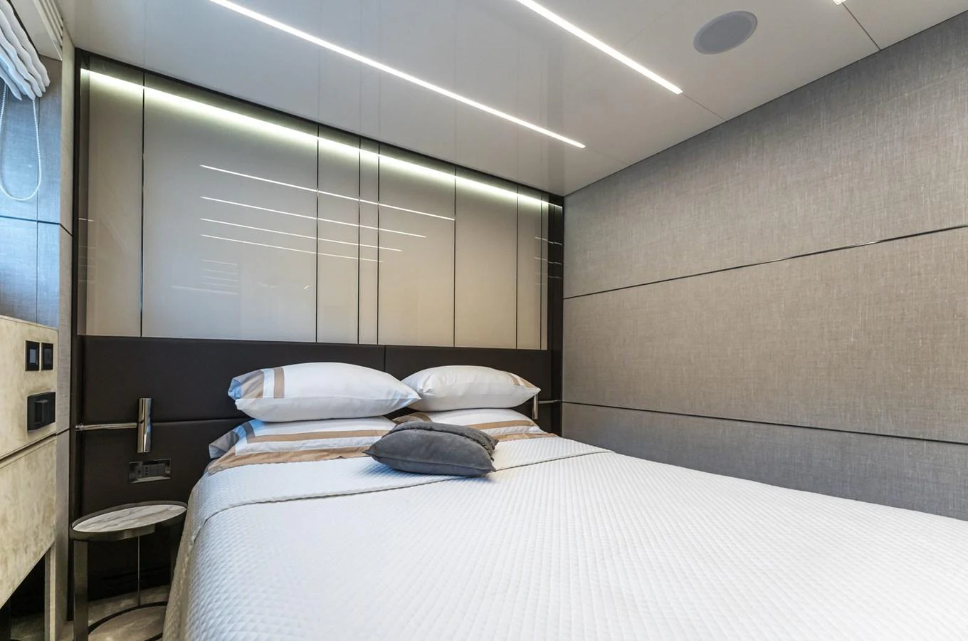 A modern stateroom featuring a comfortable bed with plush pillows and sleek, contemporary design elements. aboard ORCA I Yacht for Sale