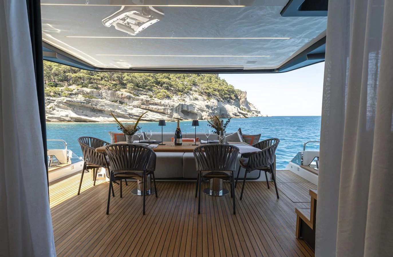 The aft deck features a stylish outdoor dining area with a stunning ocean view. aboard ORCA I Yacht for Sale