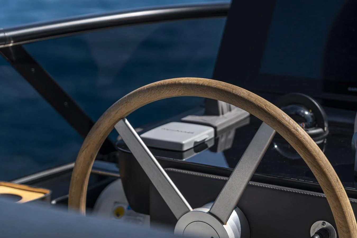 A close-up view of the yacht's helm showcasing the steering wheel and navigation equipment. aboard ORCA I Yacht for Sale