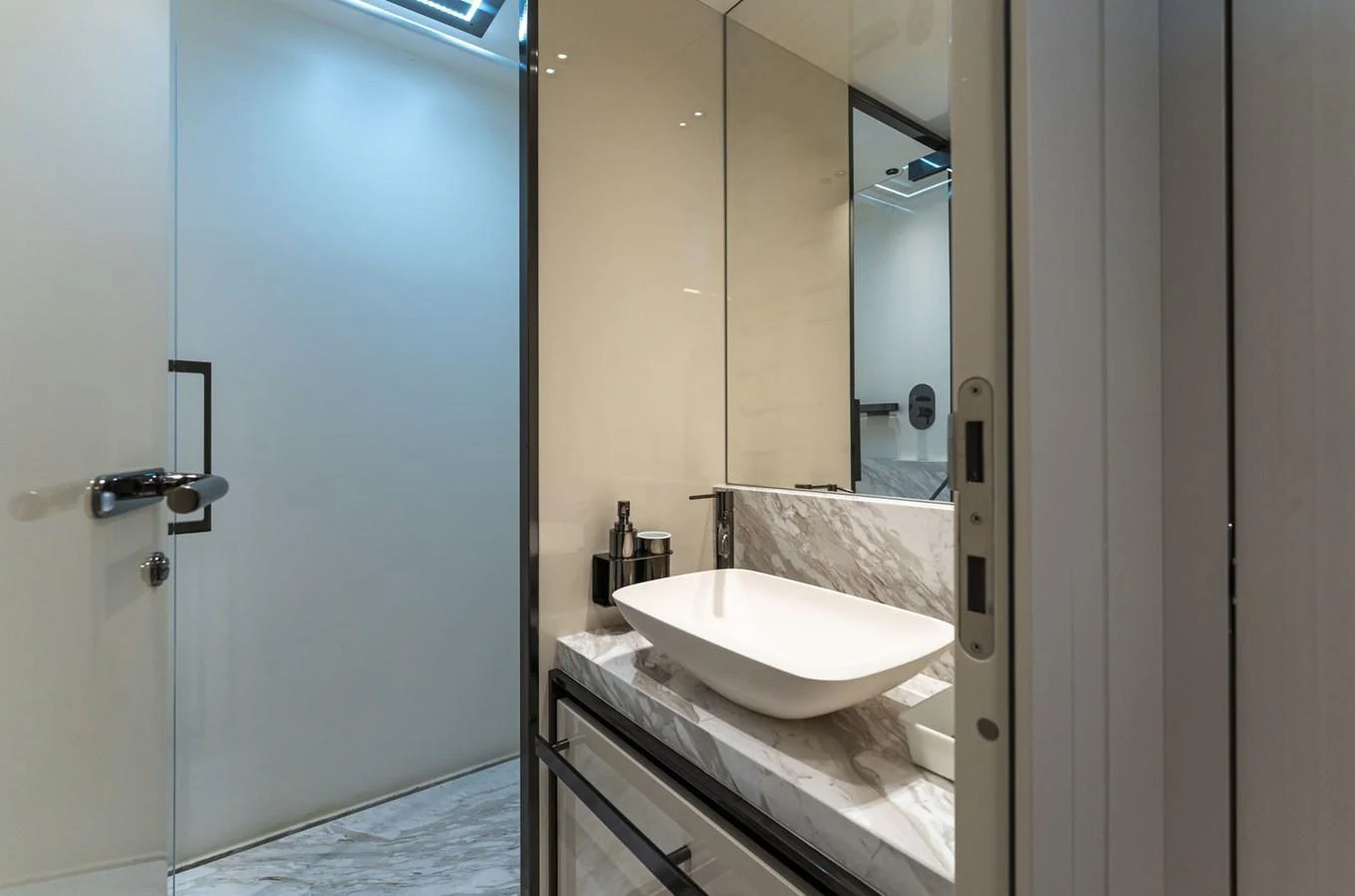 This yacht bathroom features a sleek, modern design with a marble countertop and contemporary fixtures. aboard ORCA I Yacht for Sale