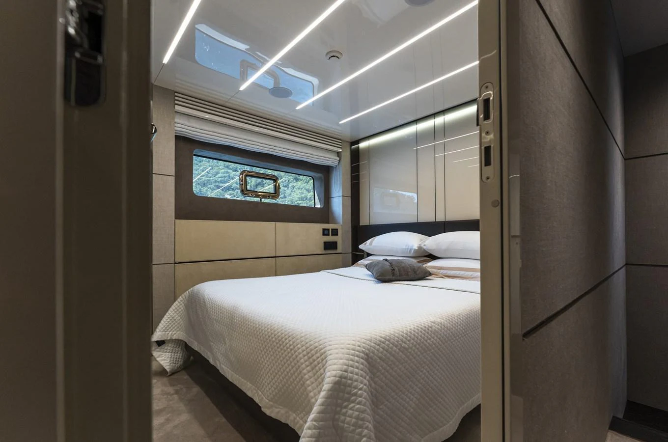 The stateroom features a comfortable bed with modern decor and ample natural light. aboard ORCA I Yacht for Sale