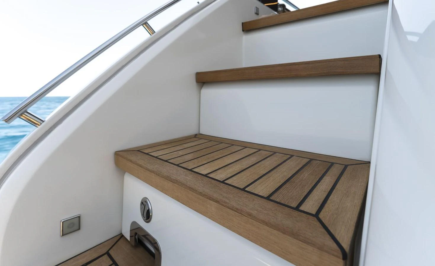 Elegant wooden steps lead up to the upper deck, showcasing fine craftsmanship and attention to detail. aboard ORCA I Yacht for Sale