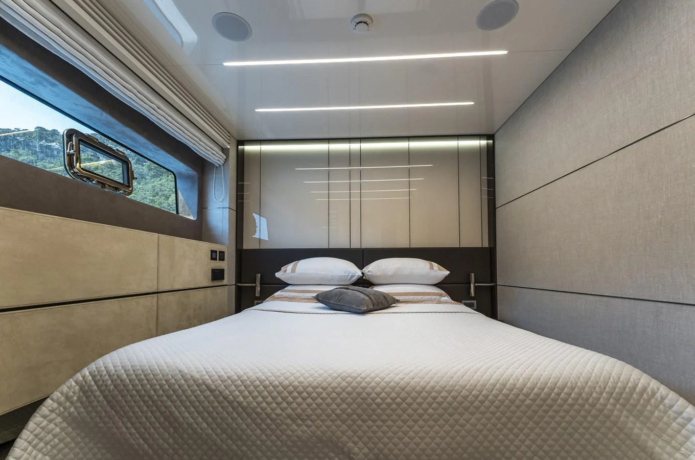 The stateroom features a comfortable bed with modern, sleek design elements and ample natural light. aboard ORCA I Yacht for Sale