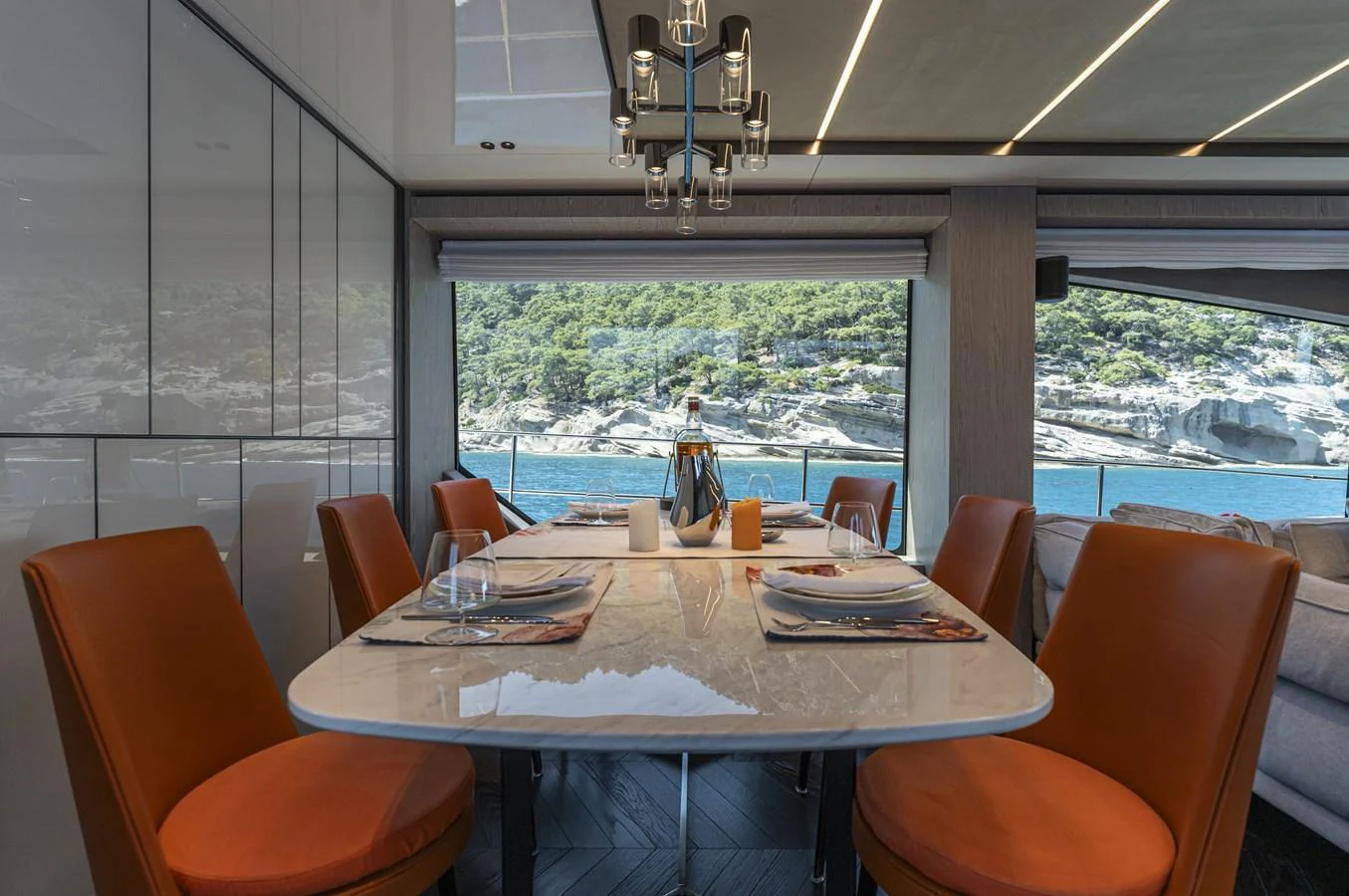 The yacht's dining area features a sleek table with comfortable seating and scenic views through large windows. aboard ORCA I Yacht for Sale
