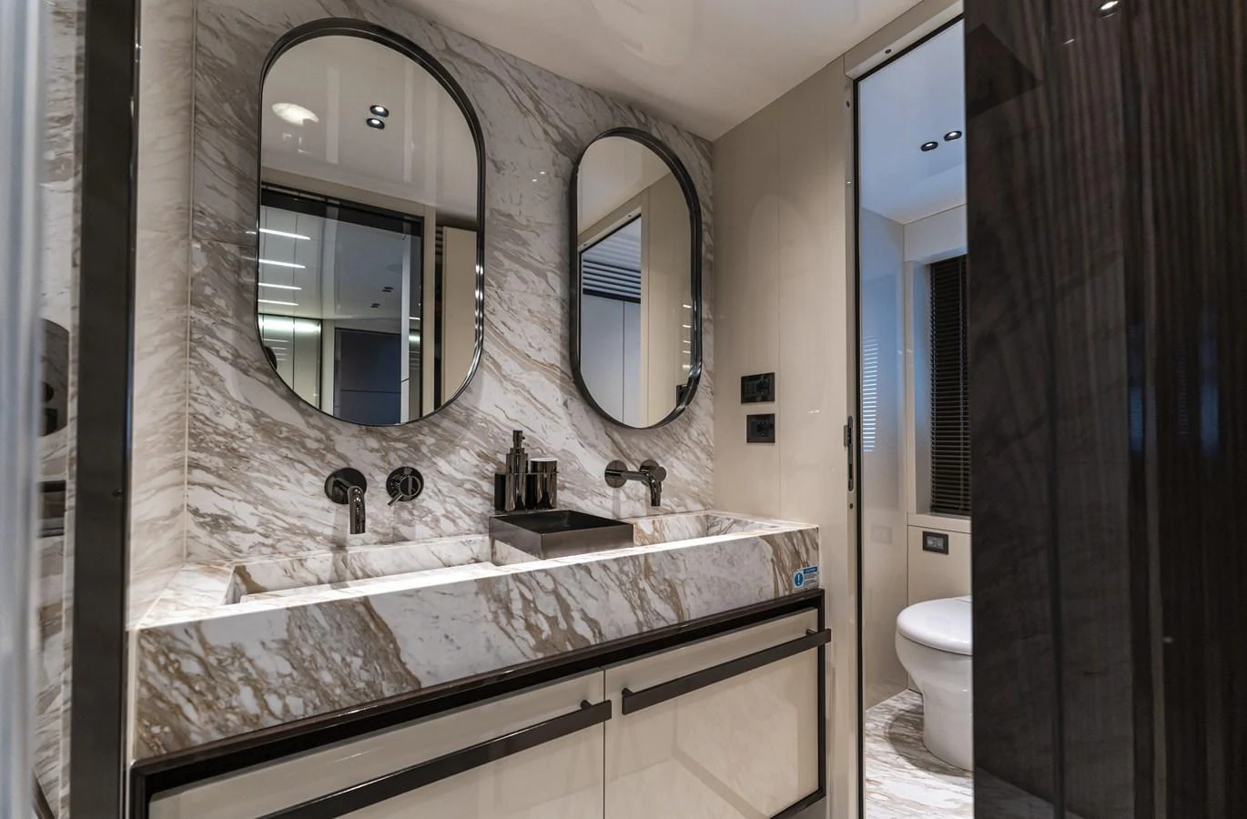 The yacht's bathroom features a luxurious double vanity with marble countertops and modern fixtures. aboard ORCA I Yacht for Sale
