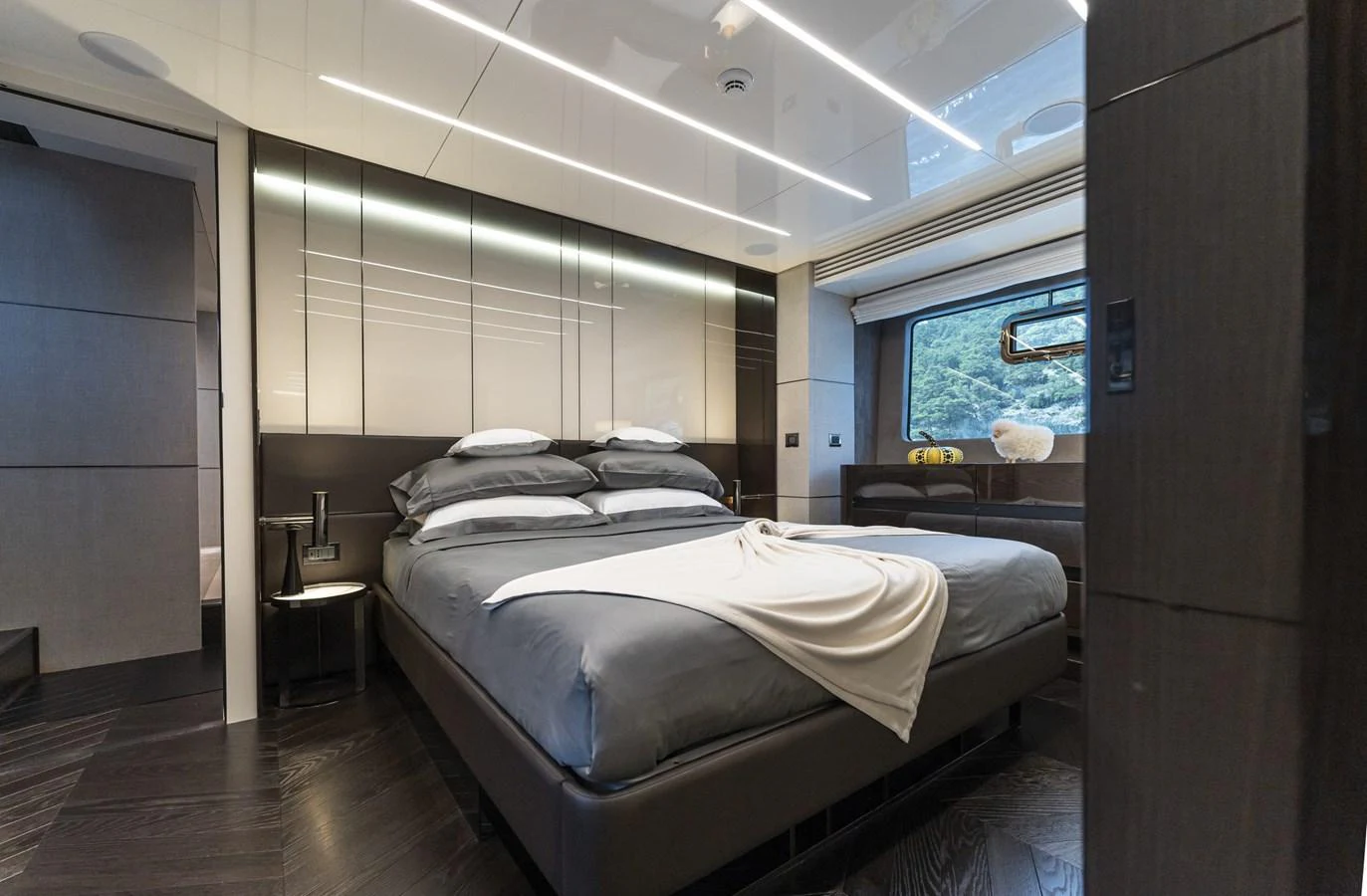 The stateroom features a luxurious bed with modern decor and ample natural light. aboard ORCA I Yacht for Sale