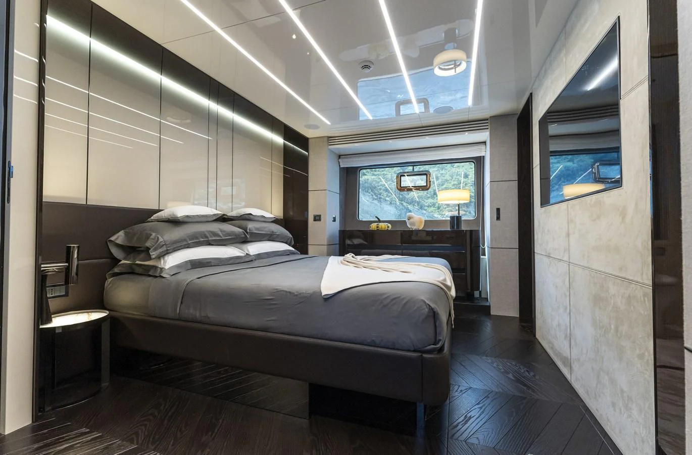 The stateroom features a luxurious bed with modern decor and ample natural light. aboard ORCA I Yacht for Sale