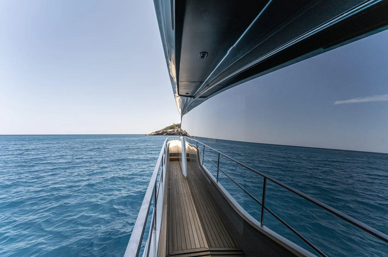 A sleek yacht exterior with a side deck view over calm blue waters. aboard ORCA I Yacht for Sale