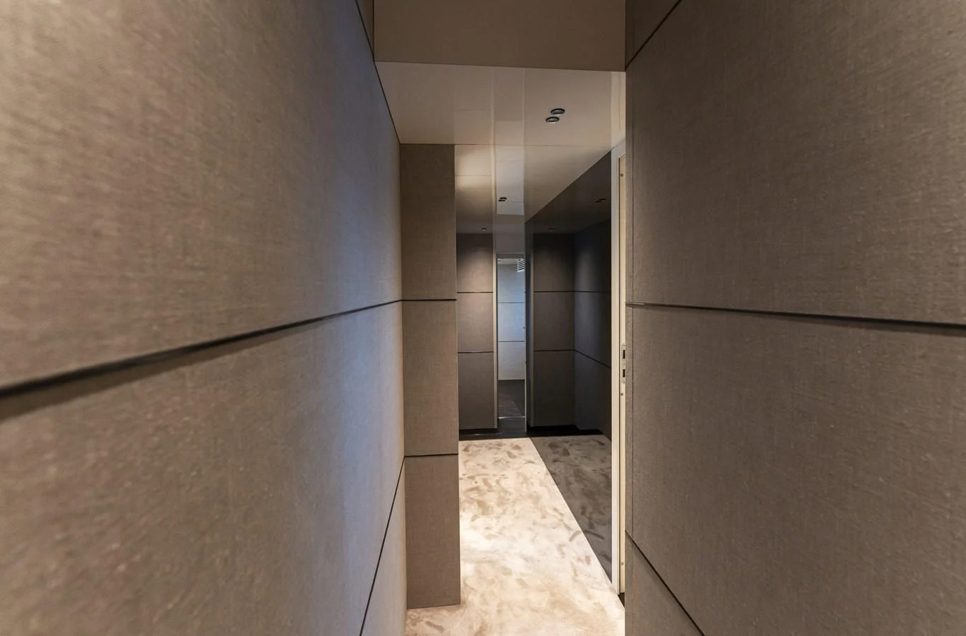 A modern hallway with sleek, neutral-toned walls and plush carpeting. aboard ORCA I Yacht for Sale