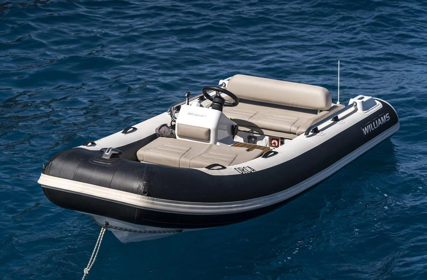 A sleek and modern tender floats on clear blue water, ready for quick and comfortable transport. aboard ORCA I Yacht for Sale