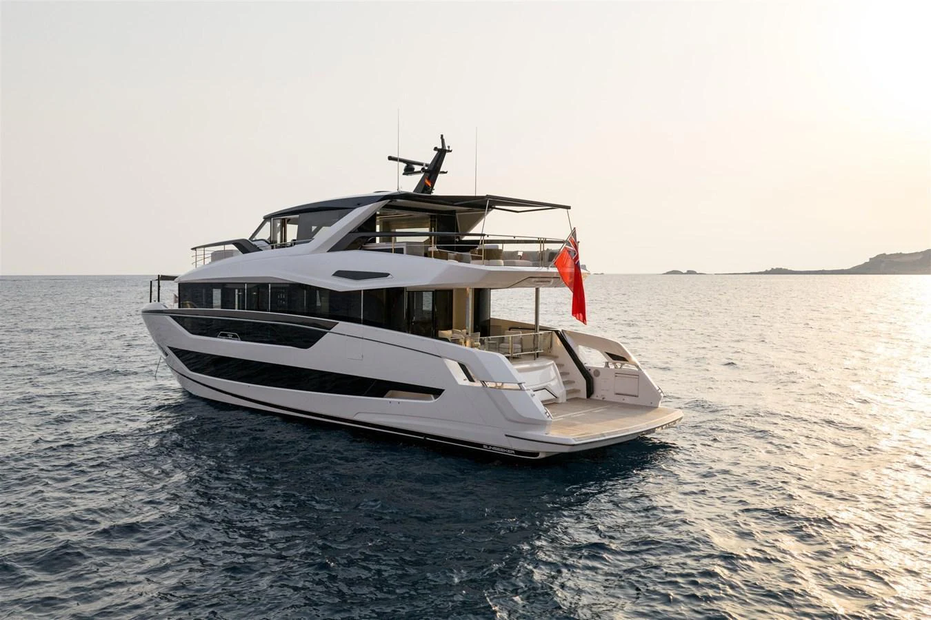 A sleek and modern yacht glides gracefully on calm waters at sunset. aboard 82 OCEAN ENCLOSED Yacht for Sale